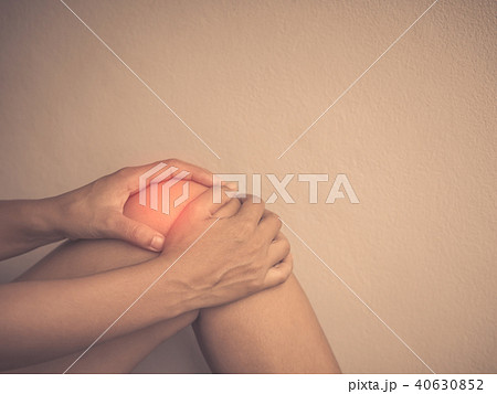 Young woman massaging her painful knee Young woman massaging her painful knee 40630852