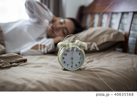 woman lying in bed suffering from sound covering  40635568