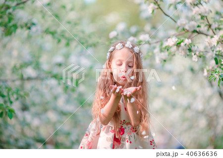 Adorable little girl in blooming cherry tree garden on spring day 40636636