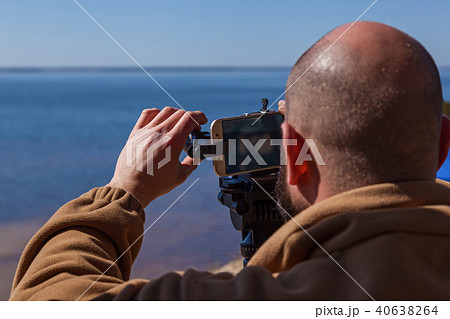 man takes pictures on the phone with lenses man takes pictures on the phone with lenses 40638264