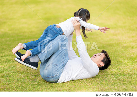 Dad is playing with him daughter in the park. 40644782