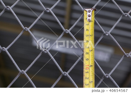 tape measure yellow on wire mesh cage tape measure yellow on wire mesh cage 40654567