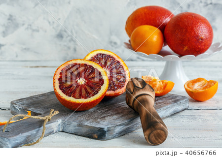 Blood orange cut in half and wooden citrus press. Blood orange cut in half and wooden citrus press. 40656766