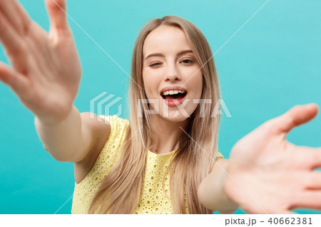 Close-up portrait of attractive young woman stretching her arms, wants to hug you. Isolated on blue Close-up portrait of attractive young woman stretching her arms, wants to hug you. Isolated on blue 40662381