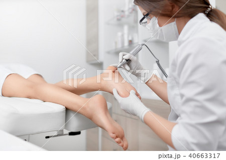 Podiatrist making procedure for client foot with special equipment. 40663317