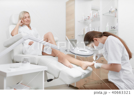 Podiatrist making procedure for client foot with special equipment. 40663321