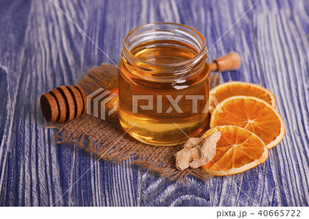 Honey in glass jar, ginger and dry slices of orange on vintage wooden background. Aromatic spices. 40665722
