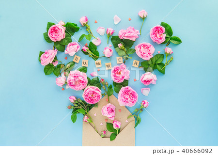 Close up creative layout with pink tea rose flowers, leaves fly out of croped craft paper envelope 40666092