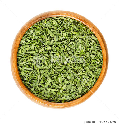 Dried chives in wooden bowl over white 40667890