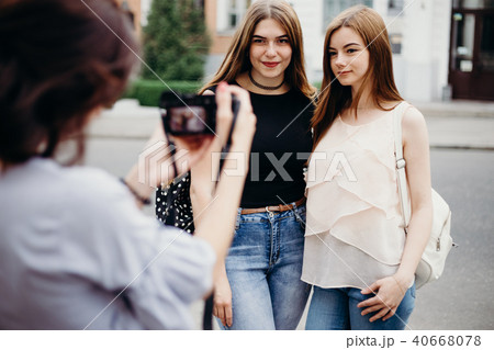 Woman taking picture of her friends using camera Woman taking picture of her friends using camera 40668078