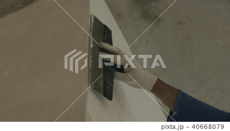 worker applying putty on the wall near corner worker applying putty on the wall near corner 40668079