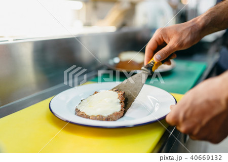 Male cook prepares fresh salad for burger 40669132