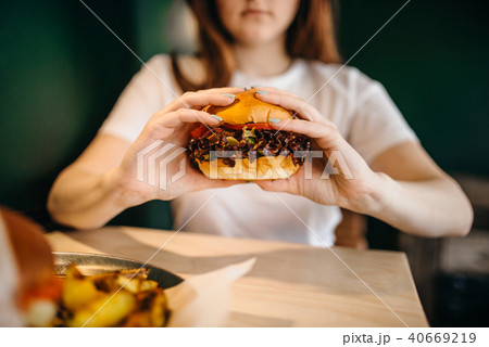 Female person eats fresh burger 40669219