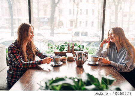 Two girlfriends met in a cafe to drink coffee Two girlfriends met in a cafe to drink coffee 40669273