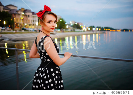 A beautiful young woman dressed stand on the  40669671