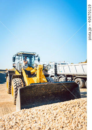 Construction workers doing earthworks with wheel loader 40670119