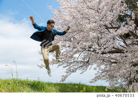 桜をバックにジャンプをする男性 桜をバックにジャンプをする男性 40670533