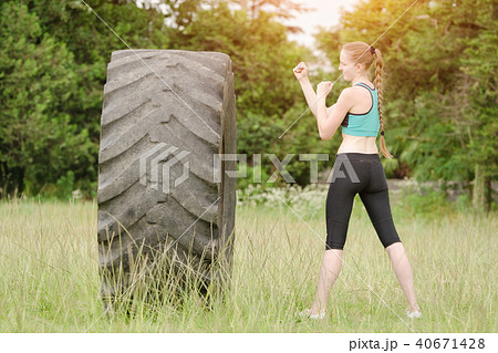 Young woman boxing with the tire. Workout 40671428