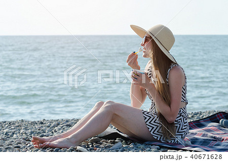 Girl in hat eating ice cream on the beach Girl in hat eating ice cream on the beach 40671628