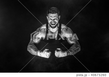 Sportsman muay thai boxer fighting on black background with smoke. 40673260