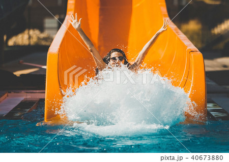 joyful woman going down by the slide in aqua park joyful woman going down by the slide in aqua park 40673880