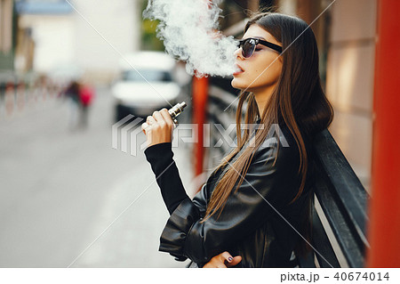stylish girl smoking an e-cigarette 40674014