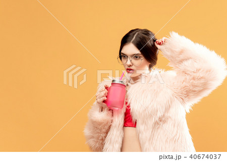Woman with pink drinking jar on yellow 40674037