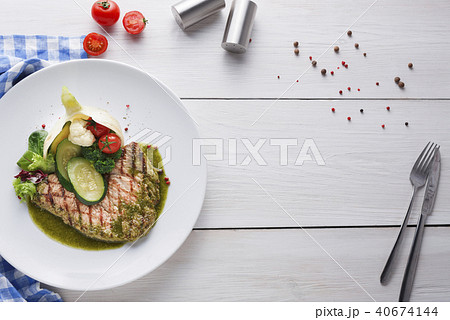 Perfectly seasoned grilled beefsteak decorated with vegetables and sauce Perfectly seasoned grilled beefsteak decorated with vegetables and sauce 40674144