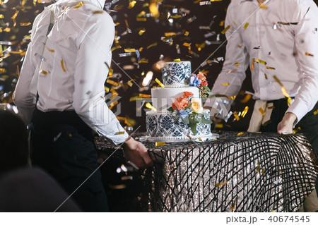 waiter will present at the restaurant. Wedding cake with flowers. Bride and groom cut sweet cake on 40674545