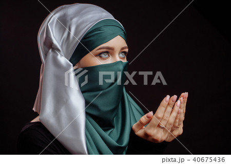 close up side view shot of Muslim young woman in green hijab is praying the God 40675436