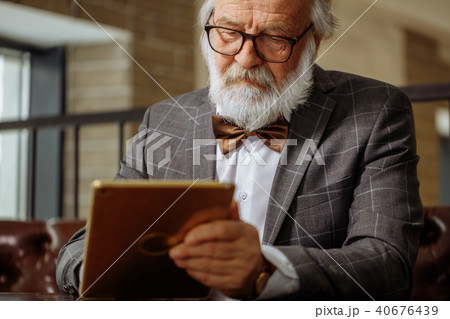 senior citizen with white hair and beard is all clued up about gadgets senior citizen with white hair and beard is all clued up about gadgets 40676439