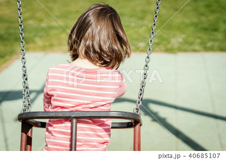 little girl is swinging on a swing at the playground 40685107