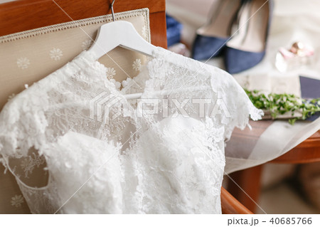 white wedding dress with lace lying on the chair. bouquet different flowers. Modern bridal bunch 40685766