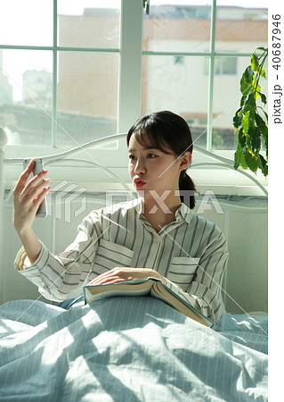 朝 若い女性 ベッド 40687946