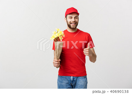 Delivery Concept: Portrait of happy flower delivery man holding beautiful bouquet flower and showing Delivery Concept: Portrait of happy flower delivery man holding beautiful bouquet flower and showing 40690138