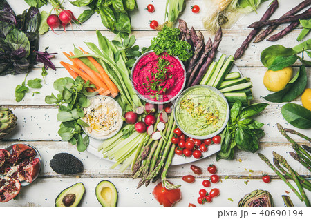 Chickpea, beetroot, spinach hummus dips with colorful vegetables and greens 40690194