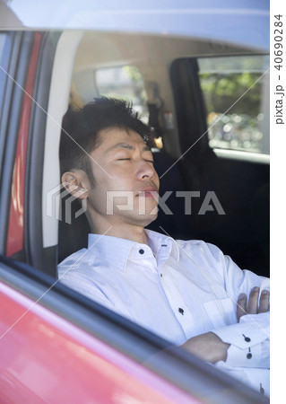 車で昼寝をするビジネスマンの写真素材
