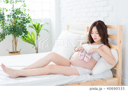 pregnant woman holding baby shoes pregnant woman holding baby shoes 40690535