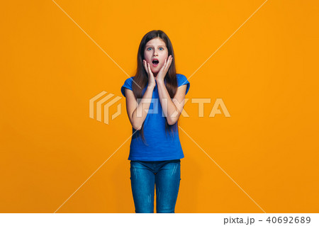 Beautiful teen girl looking suprised isolated on orange 40692689