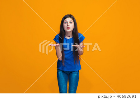 Beautiful female half-length portrait on orange studio backgroud. The young emotional teen girl Beautiful female half-length portrait on orange studio backgroud. The young emotional teen girl 40692691