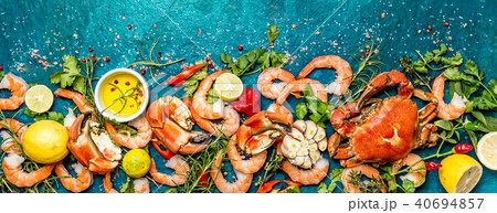 Baner. Fresh raw seafood - shrimps and crabs with herbs and spices on turquoise background. Copy 40694857