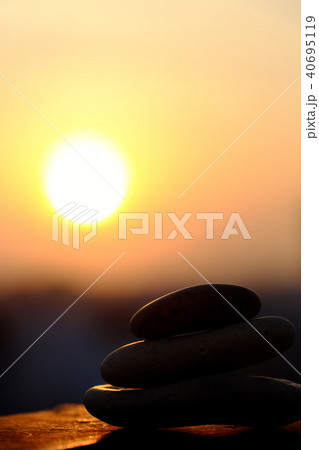 stack of pebble on yellow sun background stack of pebble on yellow sun background 40695119