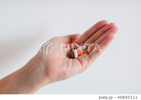 A hand is holding tablet medicines. A hand is holding tablet medicines. 40695511
