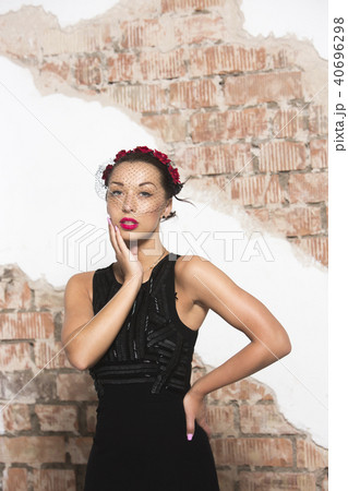 A sexy young girl in a long black dress with heels, with red lips and an attractive smile, a floral A sexy young girl in a long black dress with heels, with red lips and an attractive smile, a floral 40696298