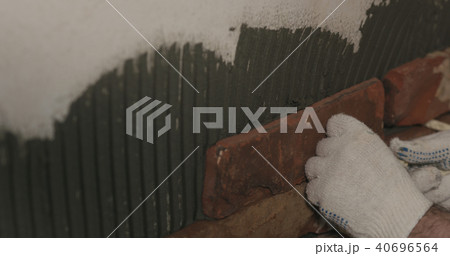 closeup worker applying brick cuts tile on the wall closeup worker applying brick cuts tile on the wall 40696564