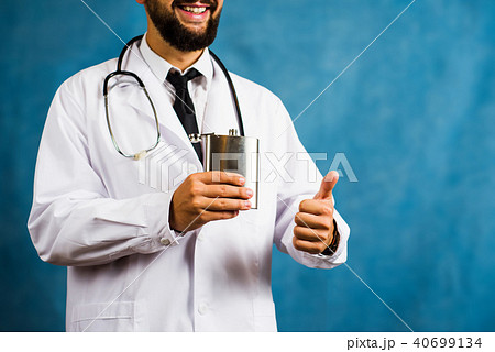 Doctor holding a hip flask close up 40699134