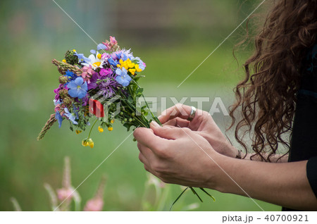 wild flowers bouquet in hand of young woman 40700921