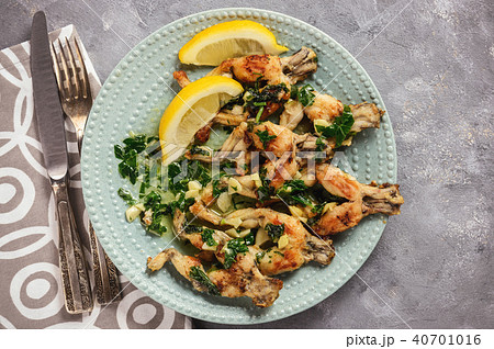 Frog legs baked with garlic butter and parsley. 40701016