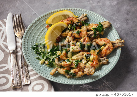 Frog legs baked with garlic butter and parsley. 40701017