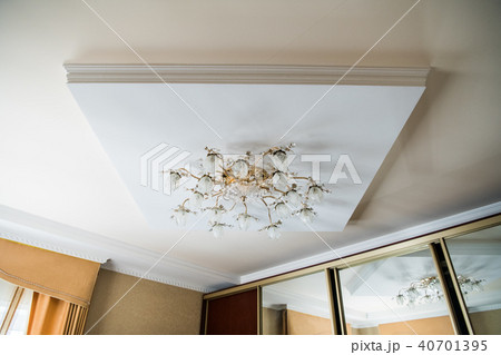 vintage chandelier hanging under white ceiling with stucco moldings 40701395